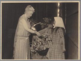 Selma Lagerlöf emottar en blomkorg från en flicka efter talet för Svenskbyborna på Operan 1929