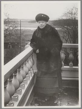 Selma Lagerlöf stående på Mårbackas balkong iklädd päls och mössa